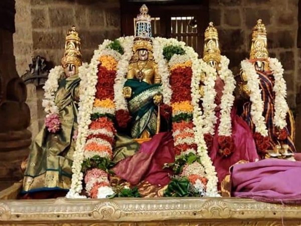 Perumal golden statue with his two wives decorated with ornaments and flowers.