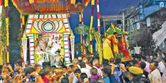 KarivalamVanthaNallur idols procession taking place with priests performing aarthi and a crowd of devotees offering prayers