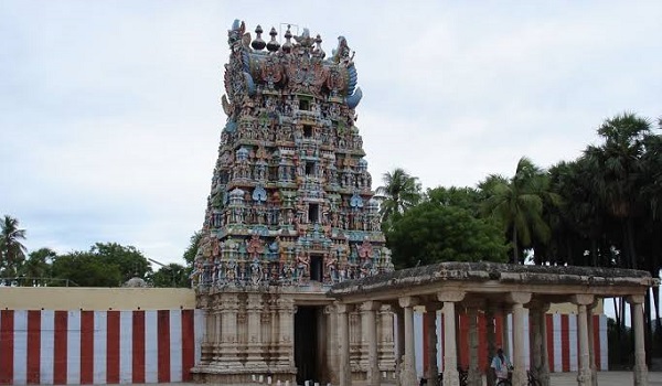 The Thiruvaragunamangai Perumal temple's main tower or Gopuram with its outer walls and a mandapam in front of the main entrance. There are coconut trees behind the temple.