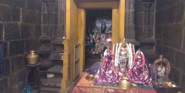The inner sanctum sanctorum of the presiding deity in Thiruvaragunamangai Perumal Temple in a seated posture with Aadhisheshan behind him. In front of the main deity is a statue of the Lord with his divine consorts. 