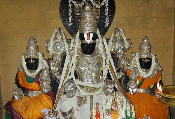 Lord Vijayasana Perumal in Thiruvaragunamangai Perumal temple is seated with his consorts Varagunamangai and Varagunavalli, wearing silver crowns and armour. The Lord is enrobed in a white dhoti and his consorts wear silk attires in orange colour.