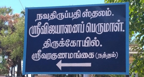 Directions to the Sri Thiruvaragunamangai Perumal temple are written in Tamil on a blue board with an arrow indicating the direction of the location.