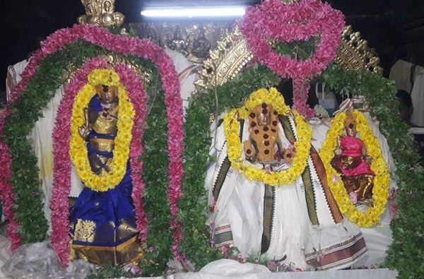 The main deity of Palayamkottai Sivan Temple with his consorts is adorned with sandalwood paste, kungumam and garlands, wearing silk attires of blue, pink, and white.