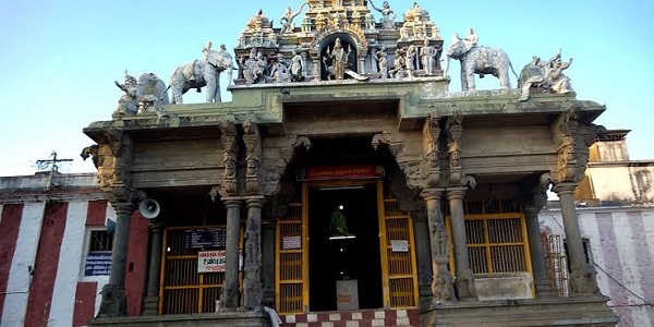 A view of Thirumalai Kumarasamy temple from the front. The Thirumalai Murugan temple's entrance with stone pillar, stone sculptures, statues, and he adjoining temple walls. 