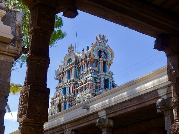 A low-angle shot of a temple gopuram of Nelliappar temple in which upper three stories of the gopuram and 'kumbhas' are visible