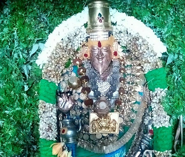 Agathiyar adorned with leaves and flowers.