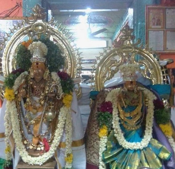 Golden statues of agathiyar and ammai adorned with flowers and ornaments.