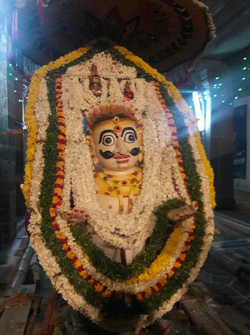 Idol in Kalakkad Sathyavageeswarar Periya Kovil adorned with layers of flowers.