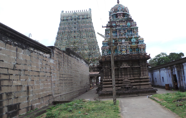 The main gopuram of the Tenkasi Kasi Viswanathar temple in the back view and a small gopuram with sanctum along the outside corridors of the temple premises in the front.