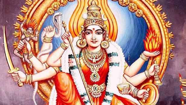 Pictorial image of Pittapurathi Amman holding a sword, sceptre, fire, bell, manuscript, a bowl, a demon, and a snake in each of her 8 hands, and wearing jewellery and a garland.
