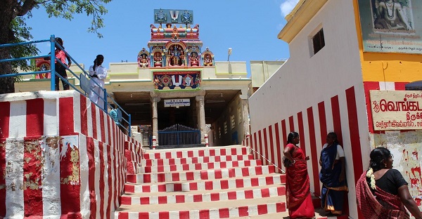 Thiruvenkatanathapuram temple entrance with stairs painted white and red and few devotees standing nearby