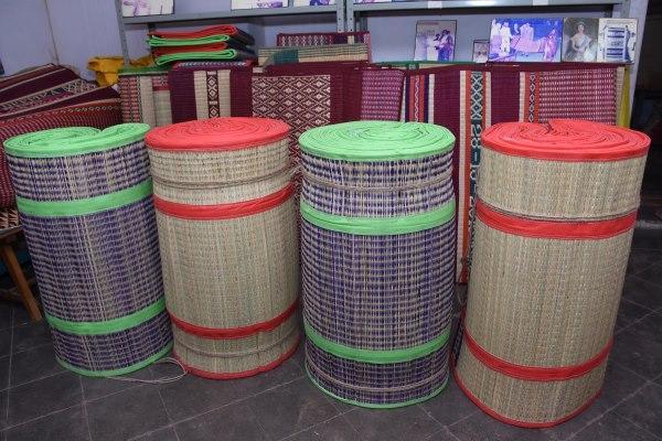 Rolls of Pathamadai mats neatly stacked and displayed