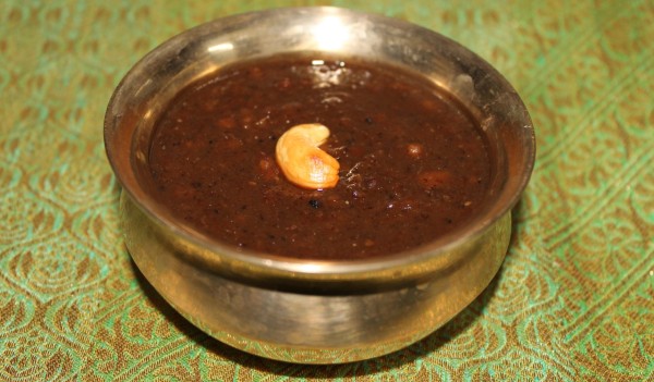 Protein-rich and decadantly sweet Kummiyanam garnished with cashwes served in a brass bowl.