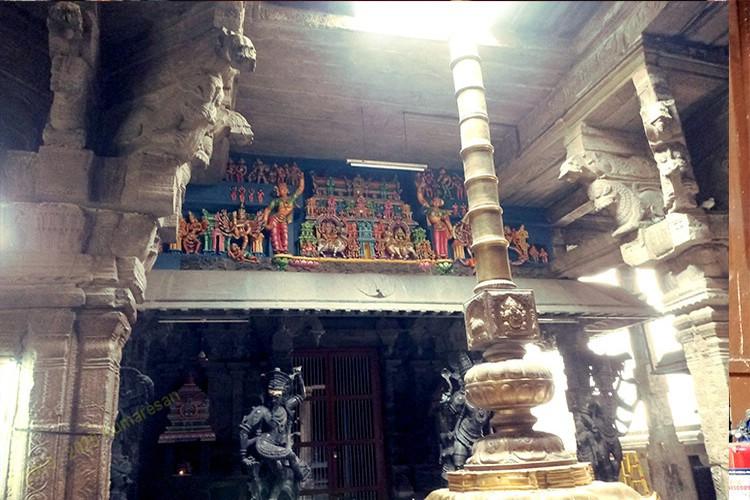 A kodimaram placed in the centre of a hindu temple extending beyond the roof.