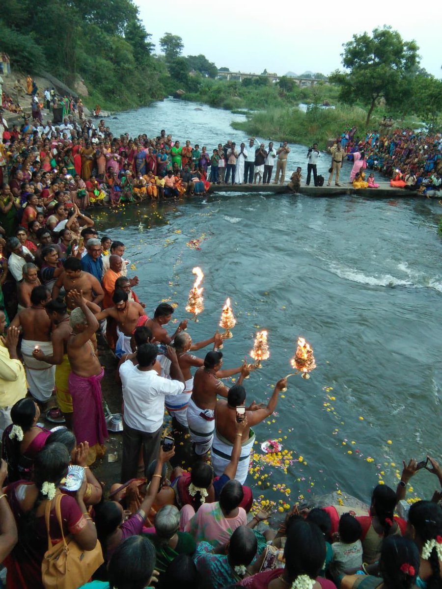 People holding holy deepaarams and praying infront of a sacred river water.