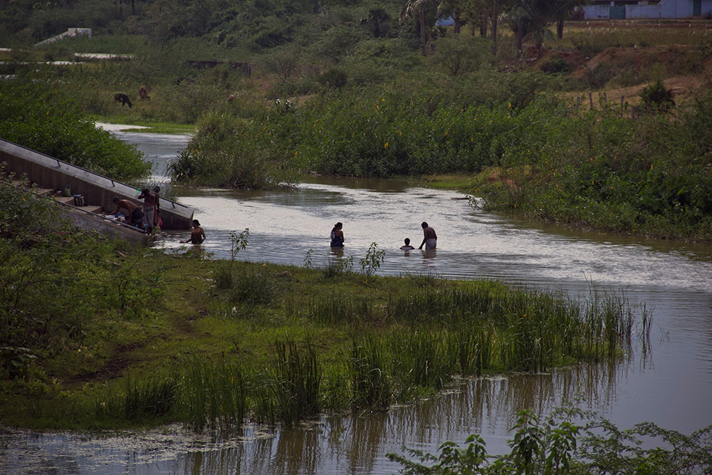 People taking bath in the Gadana River flowing through Sivasailam village.